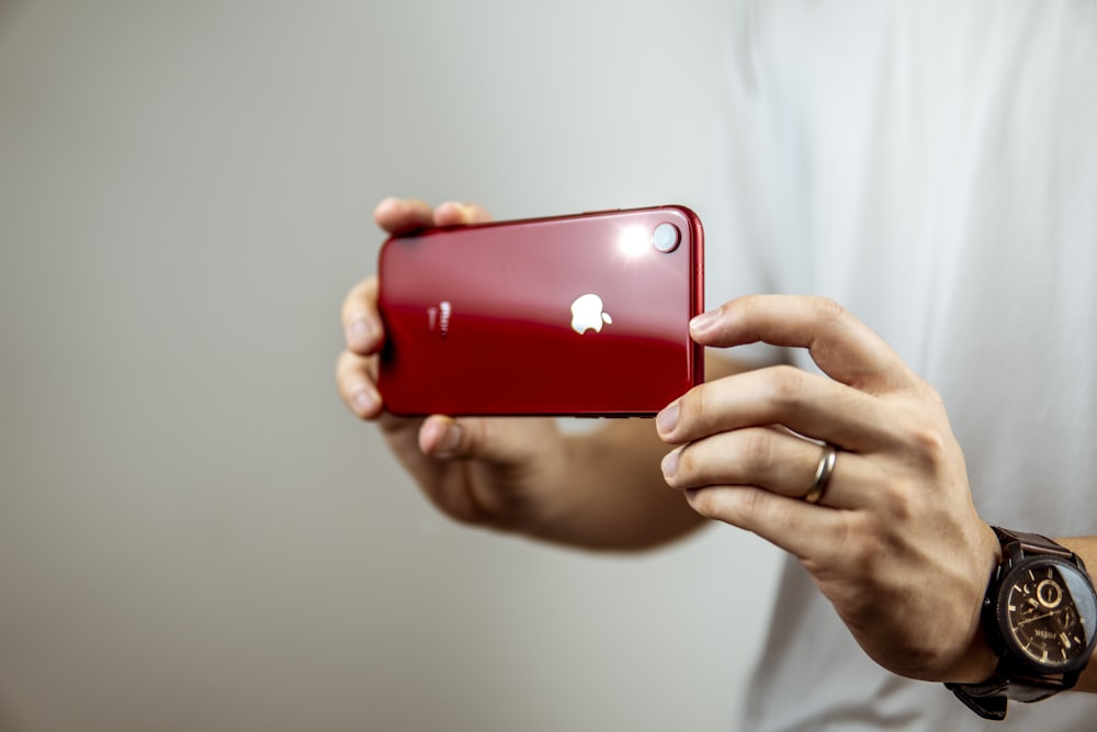 person holding red iphone 7 plus