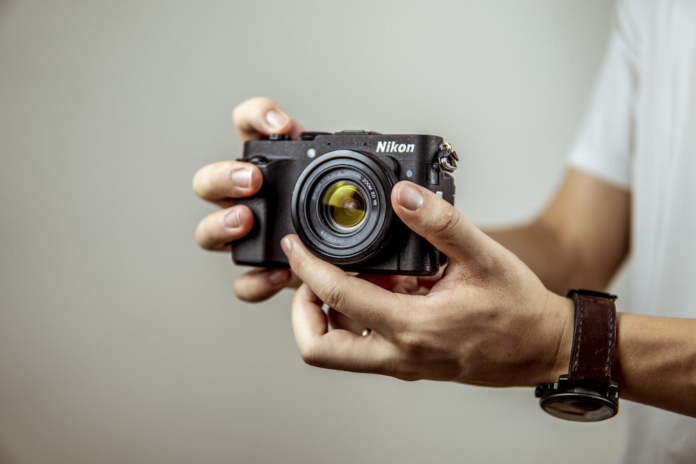 person holding black camera lens