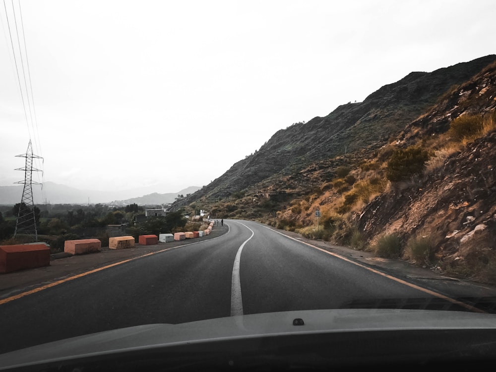 cars on road near mountain during daytime