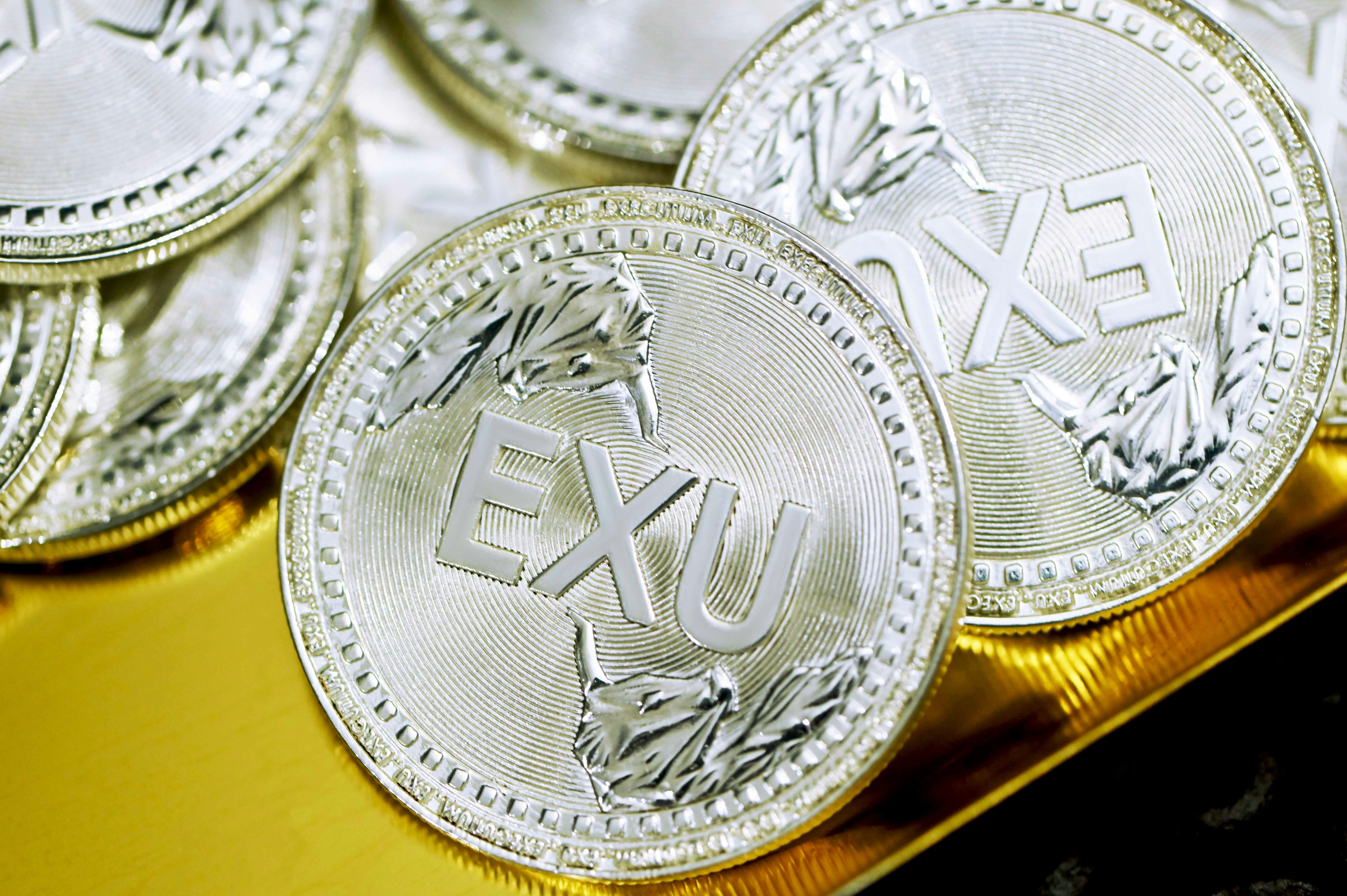 A group of silver Executium coins on a golden plate