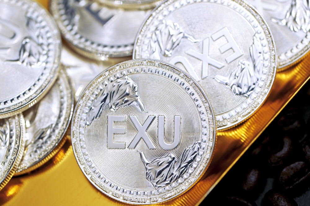 silver round coin on yellow surface