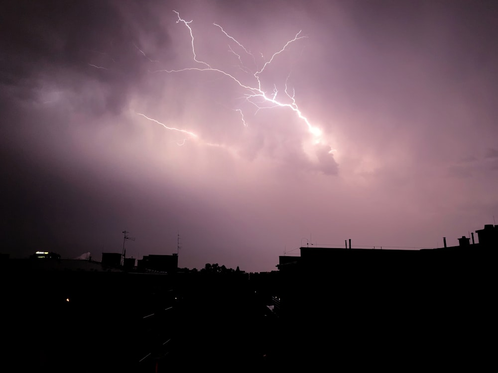 a lightning bolt hitting over a city at night