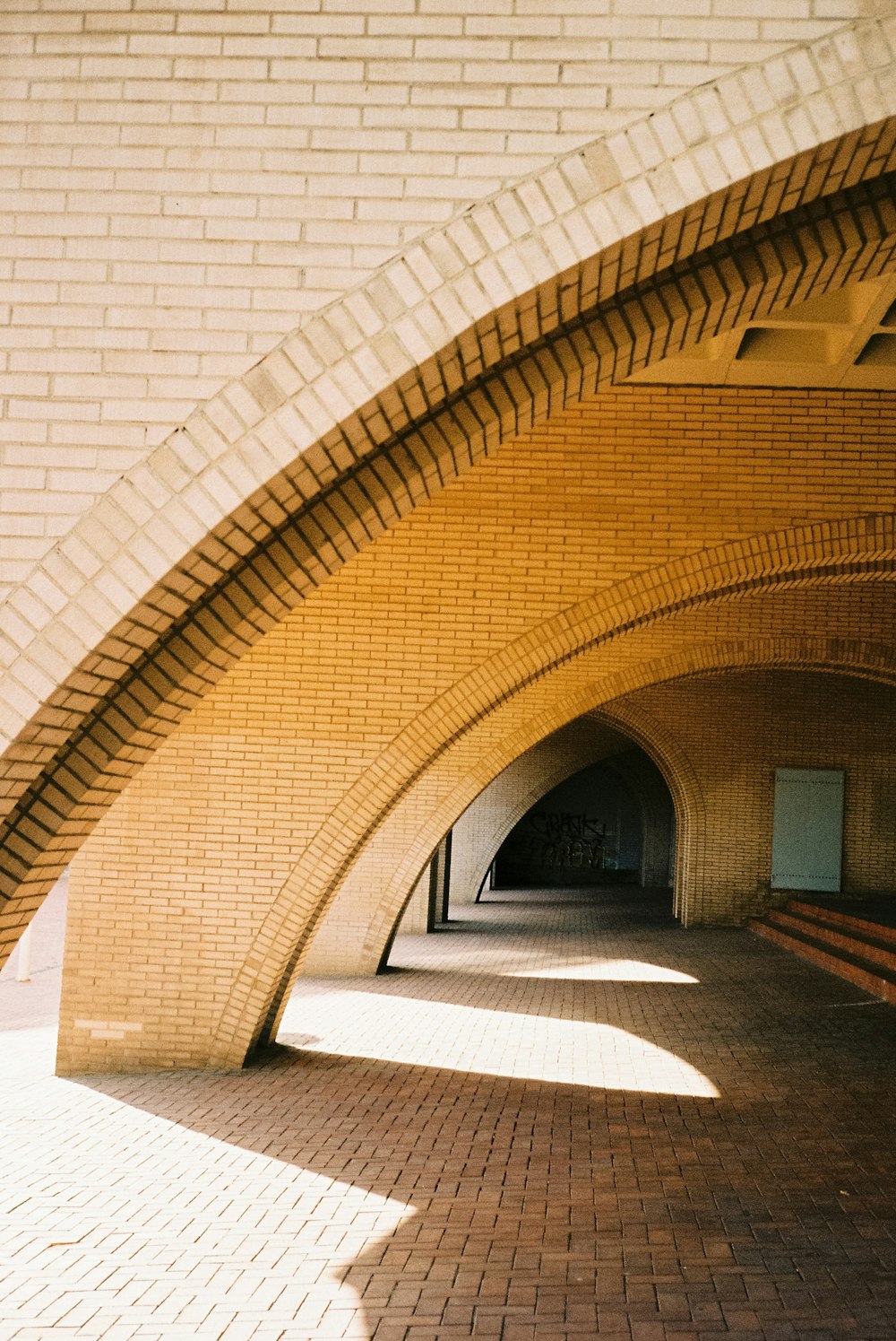 brown brick hallway with white walls