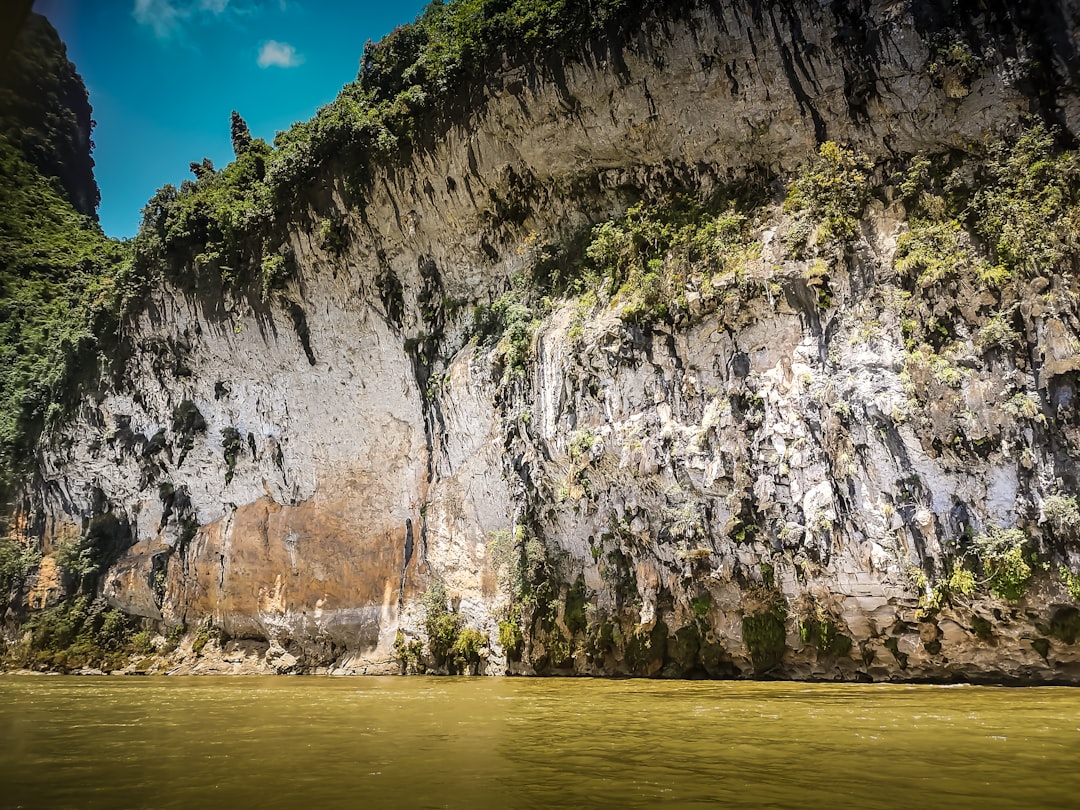 gray and black rock formation beside body of water during daytime