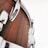Close-up view of a drum with a polished wooden finish and shiny metallic hardware, including lugs and tension rods.