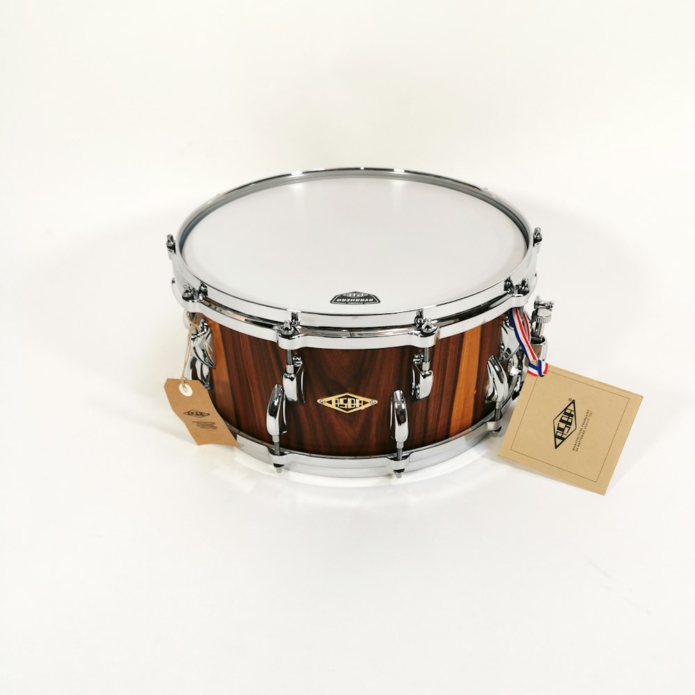 brown and silver drum on white surface