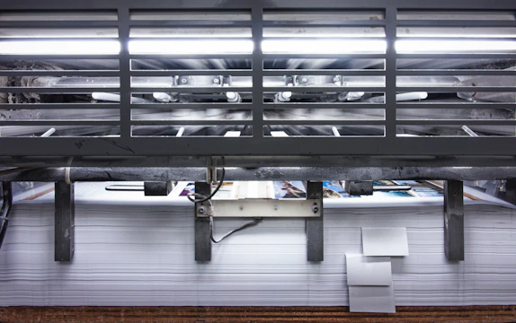 Modern printing press equipment in a sleek showroom setting with warm lighting