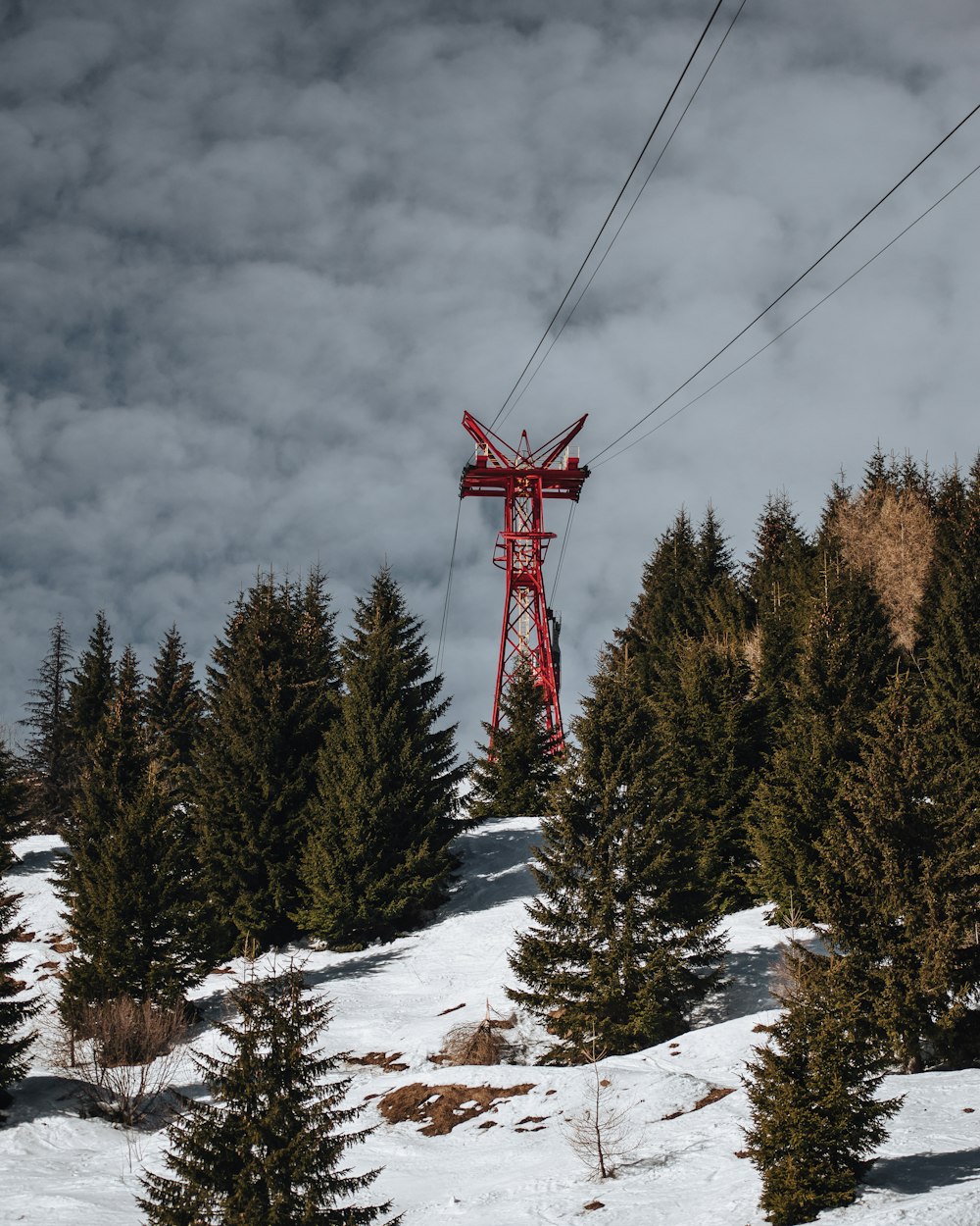 red and white cable car over snow covered ground
