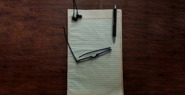 Close-up of legal documents with a pen and eyeglasses on a wooden desk.