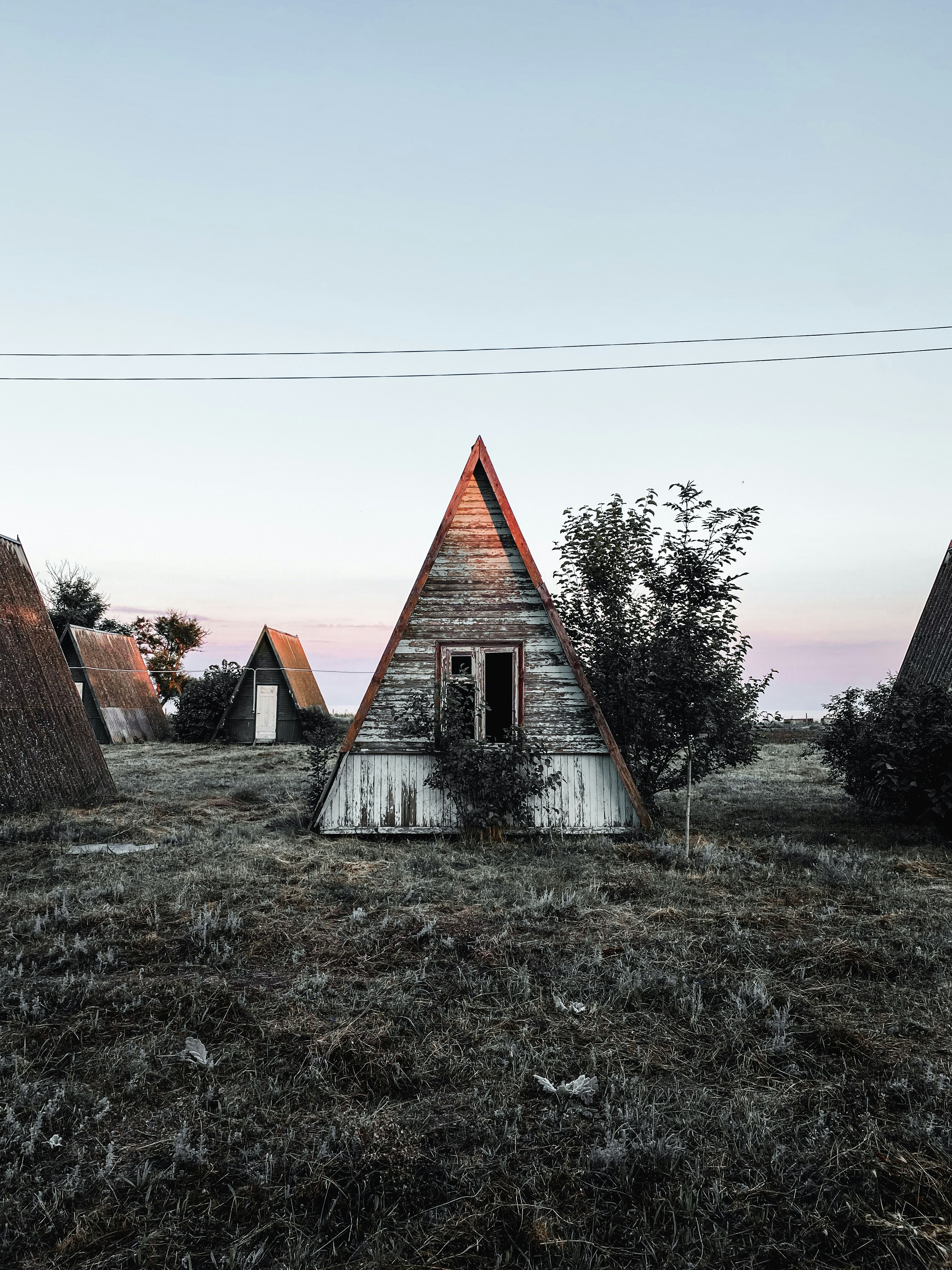 Brown and white wooden house near bare trees under white sky during ...