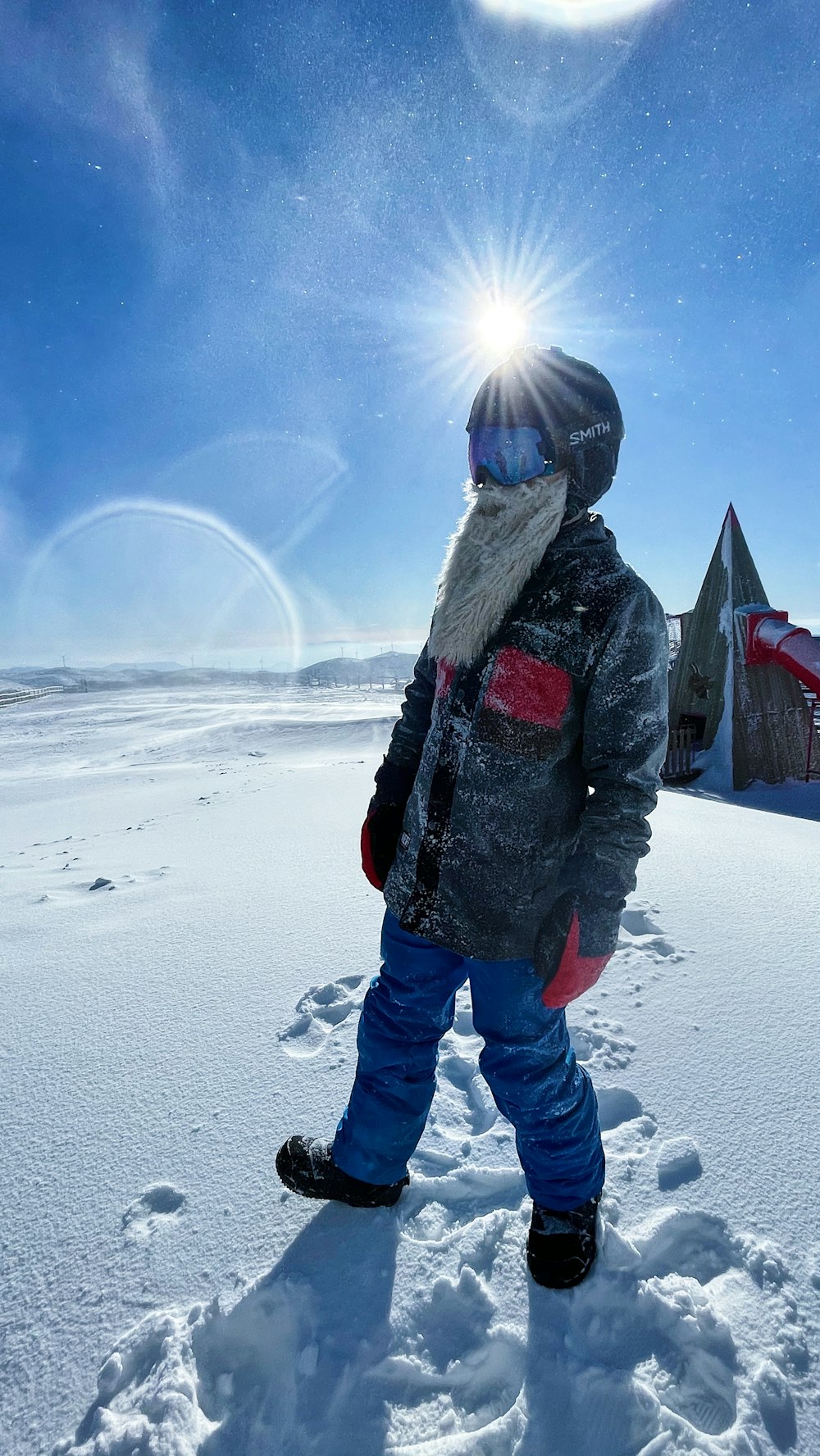 person in black jacket and blue denim jeans standing on snow covered ground during daytime