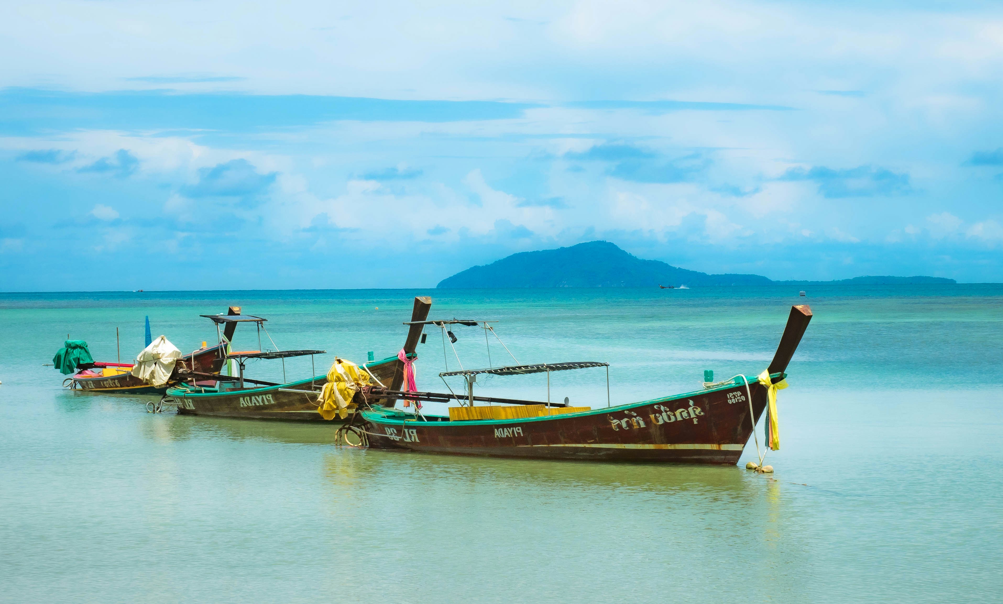 red and brown boat on body of water during daytime