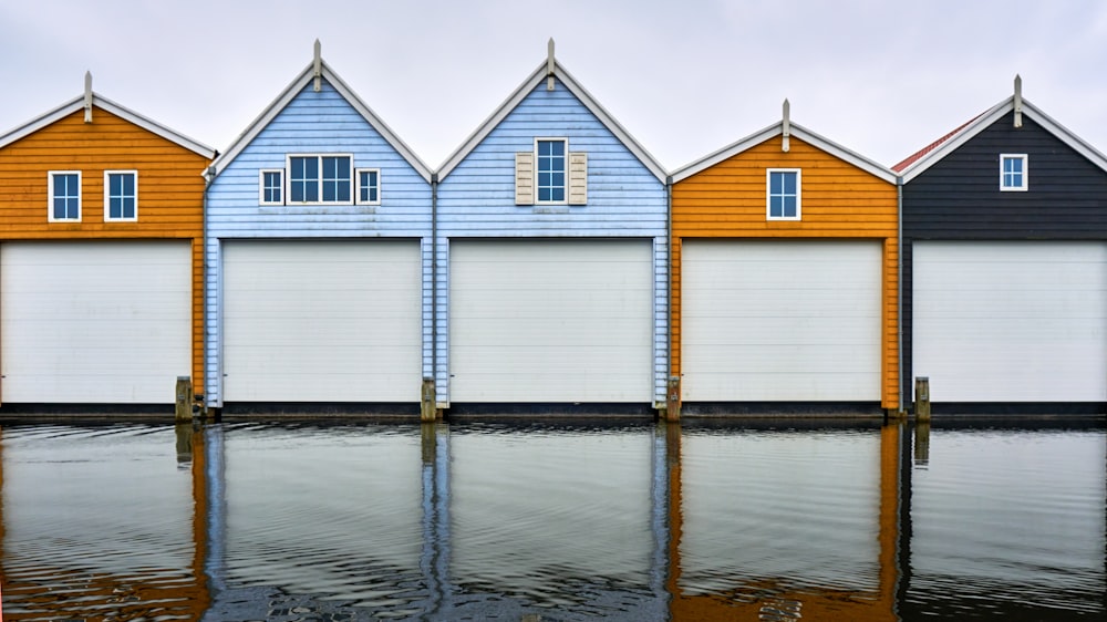 white and brown wooden house beside body of water during daytime