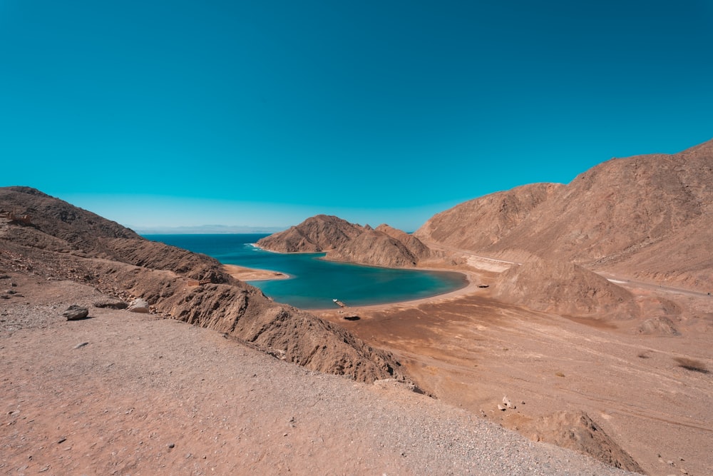 brown mountain near blue sea under blue sky during daytime