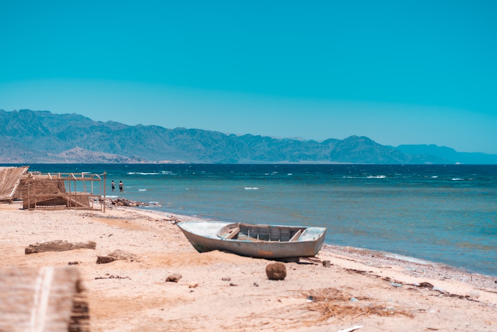 brown boat on beach shore during daytime