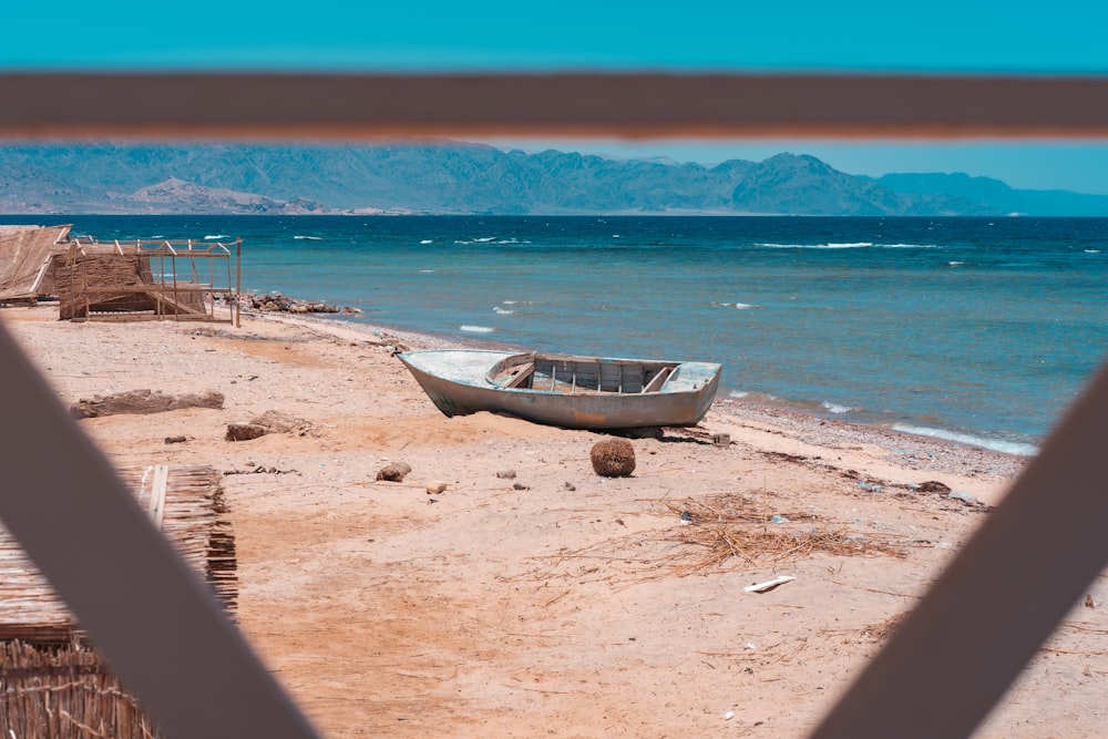 日中のビーチショアの茶色のボート