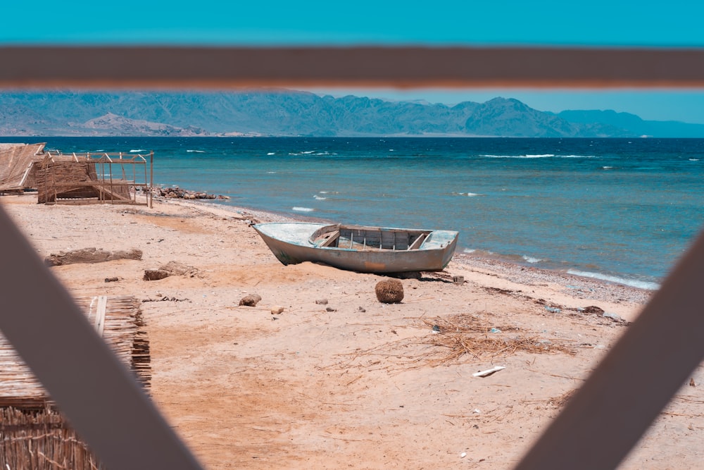 brown boat on beach shore during daytime