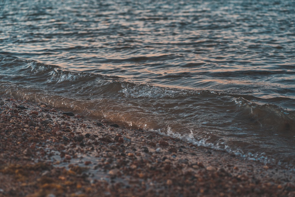 water waves on brown sand during daytime