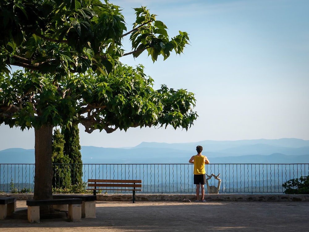 woman in yellow shirt standing near body of water during daytime