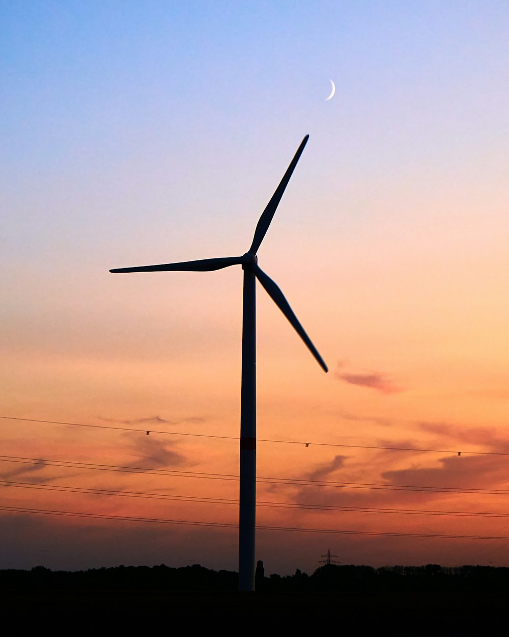 wind turbine under orange and blue sky