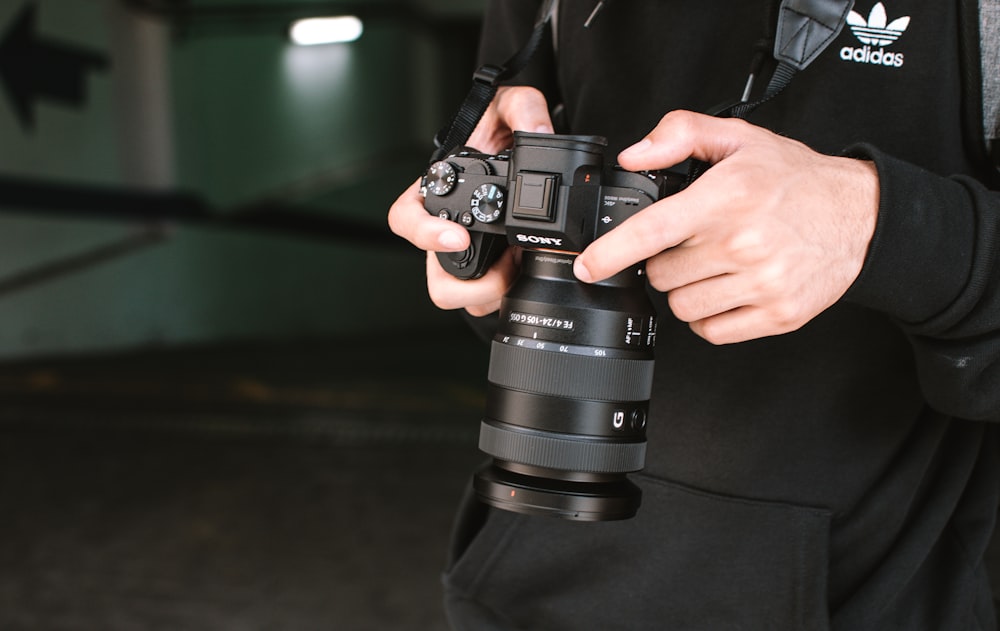 person holding black dslr camera