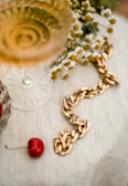 Artistic shot of a luxurious gold chain necklace resting on rich velvet fabric