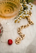 Close-up of a delicate champagne gold necklace resting on ivory fabric.