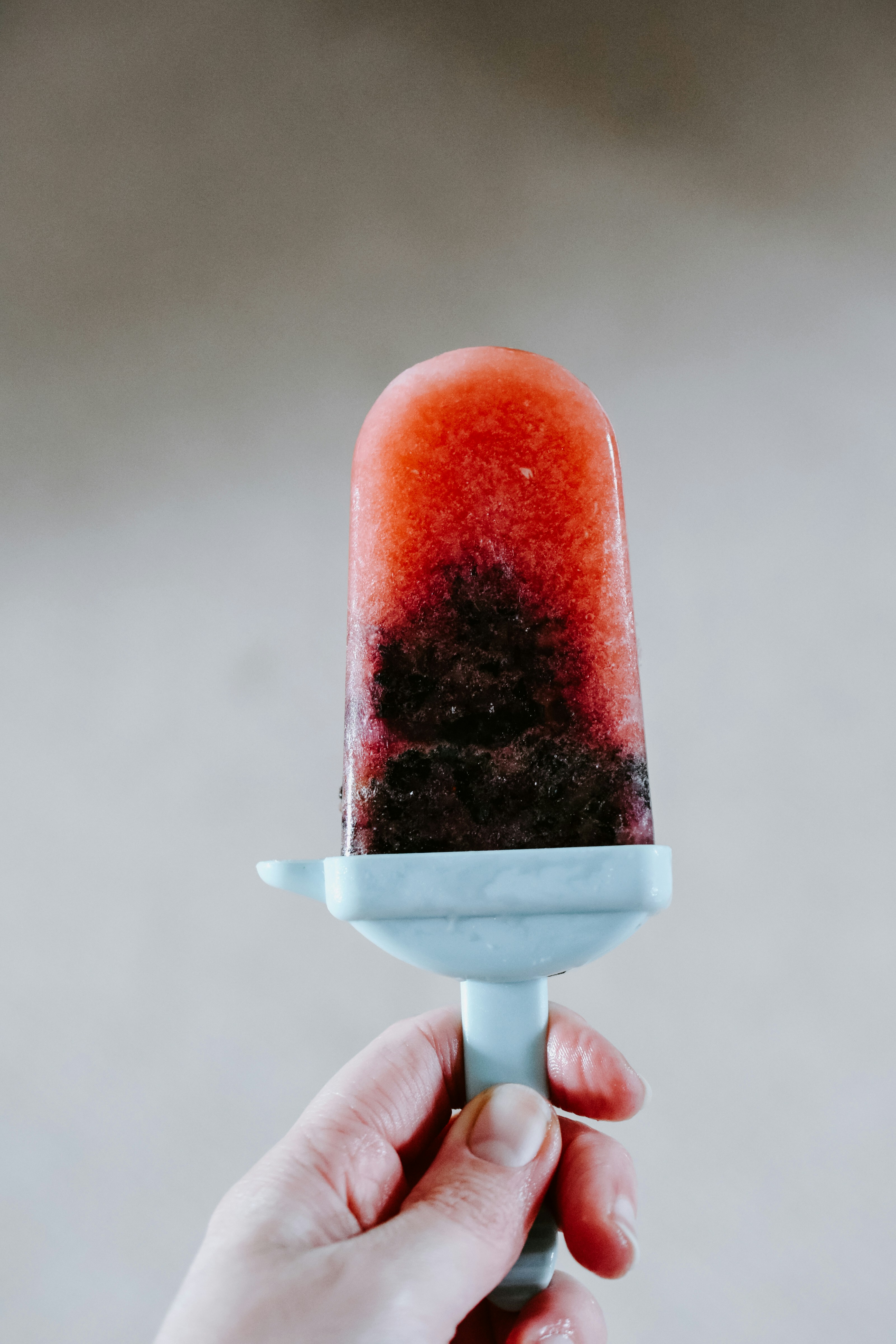 person holding red ice cream