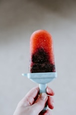 person holding red ice cream