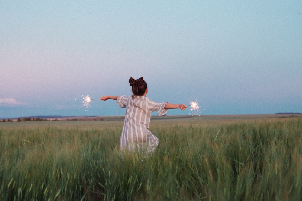 woman in white dress standing on green grass field during daytime