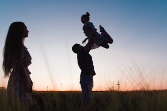 man in black jacket carrying child during daytime