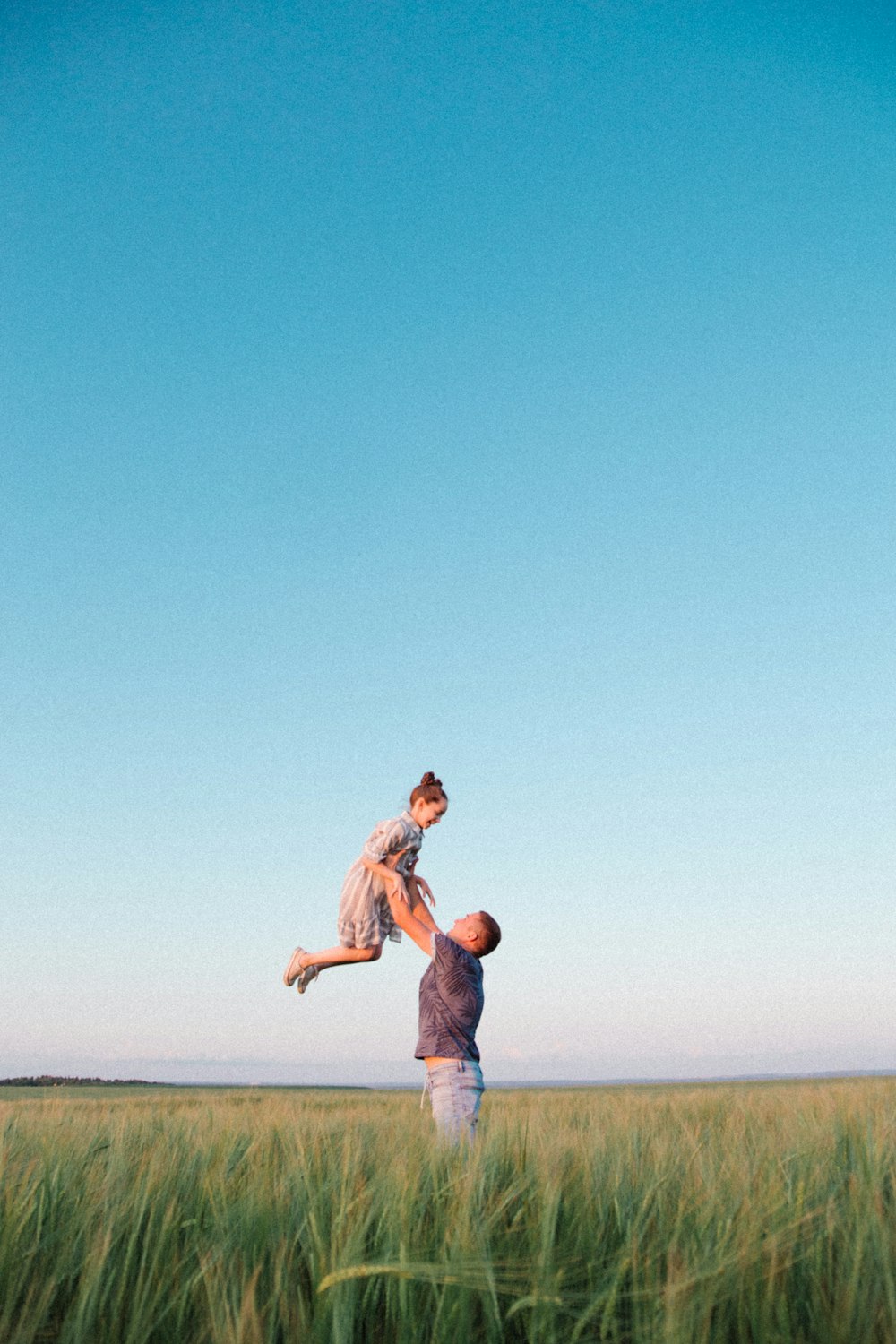 man in blue denim jeans jumping on beach during daytime