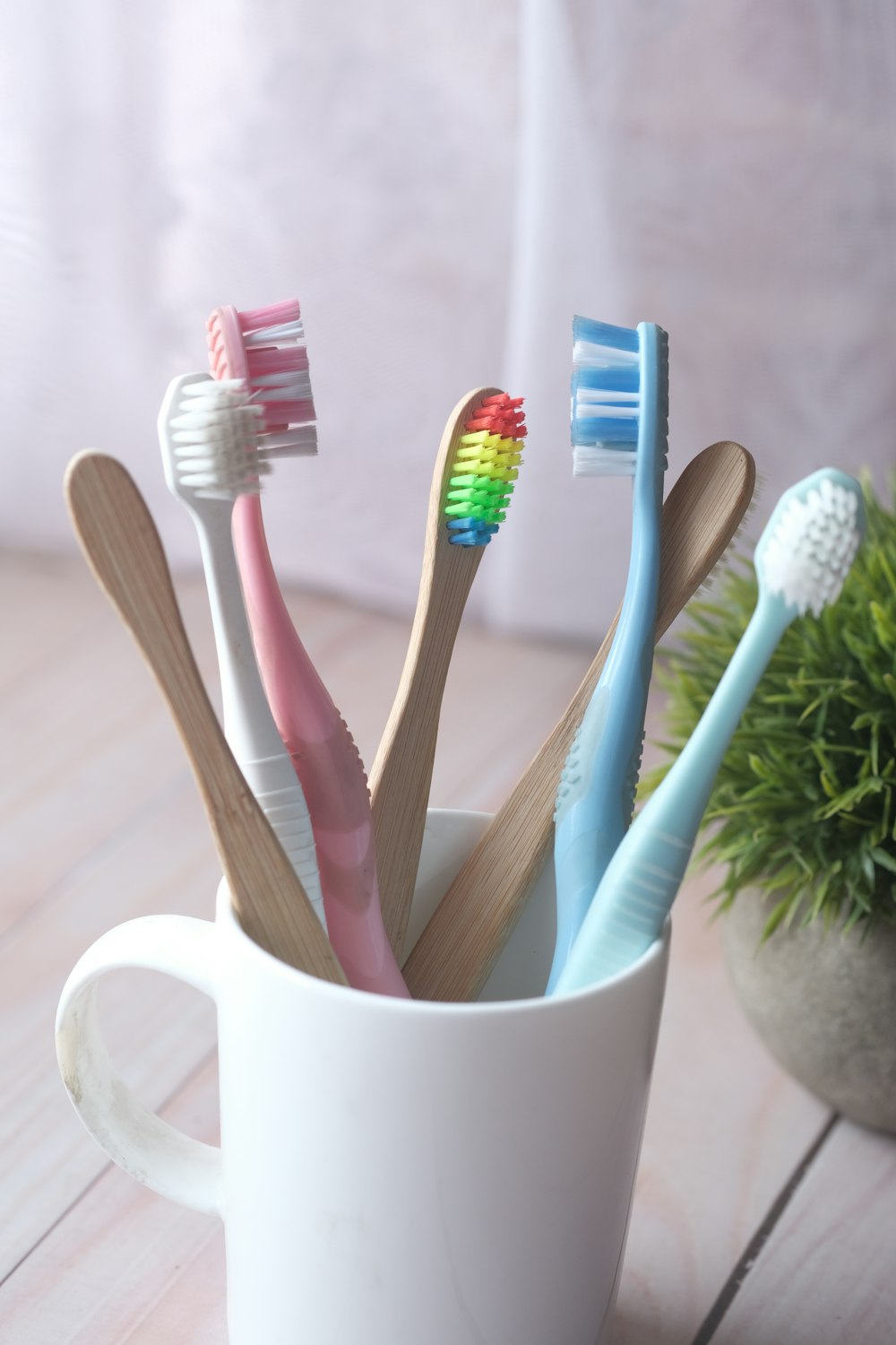 white and blue toothbrush in white ceramic mug