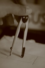 gray scale photo of person holding paper clip