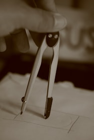 gray scale photo of person holding paper clip