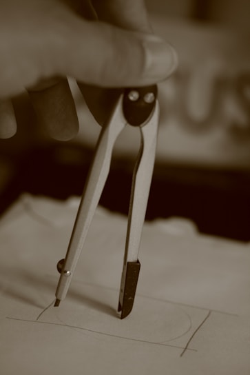 gray scale photo of person holding paper clip