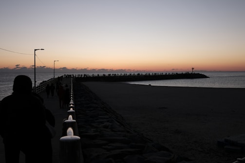 Sunset over Qingdao’s iconic Zhanqiao Pier with people strolling
