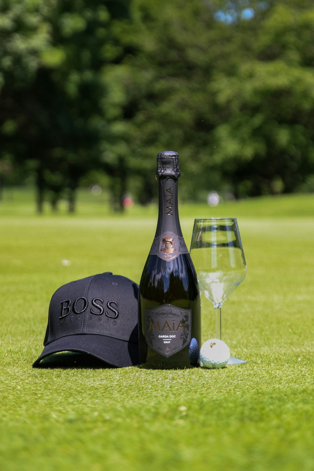 black wine bottle beside wine glass on green grass field during daytime. How Much Water Should I Drink While Golfing?