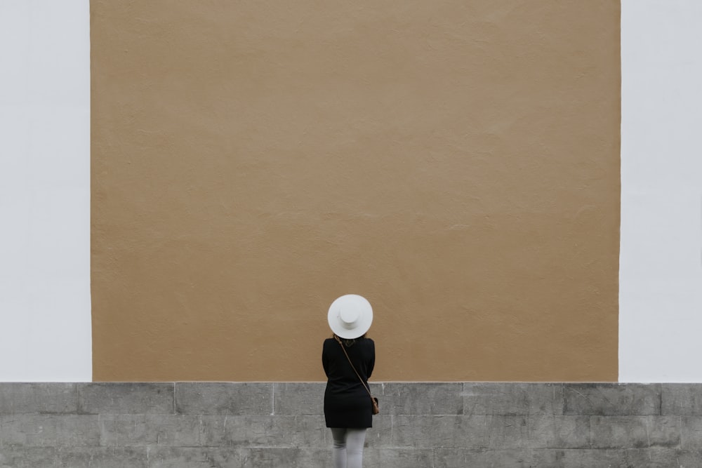 man in black shirt and black pants standing on brown concrete floor