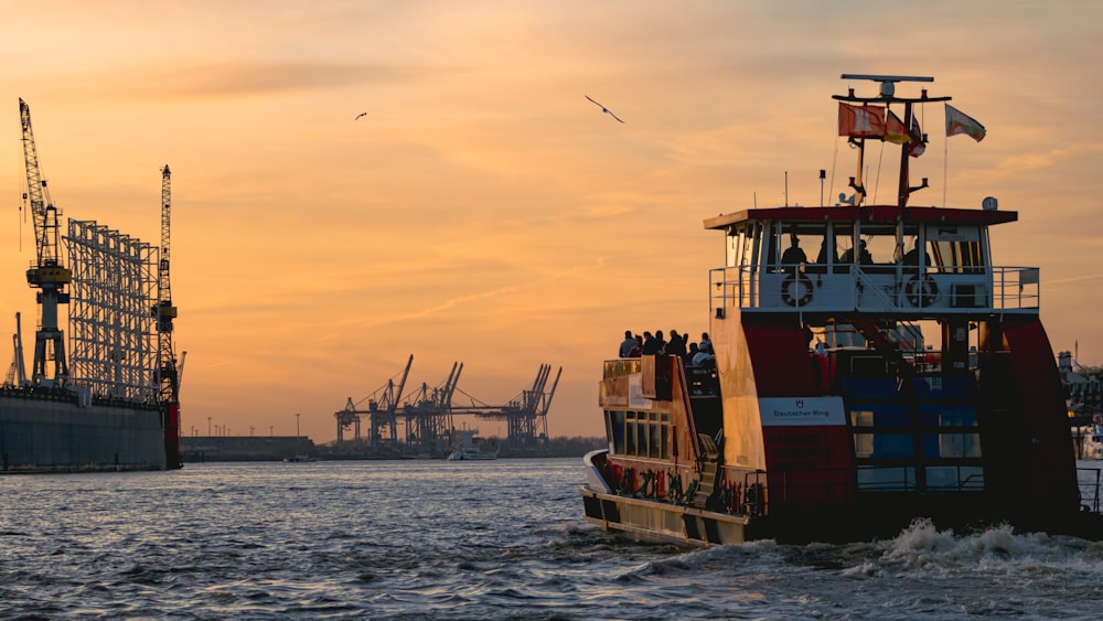 red and white ship on sea during sunset