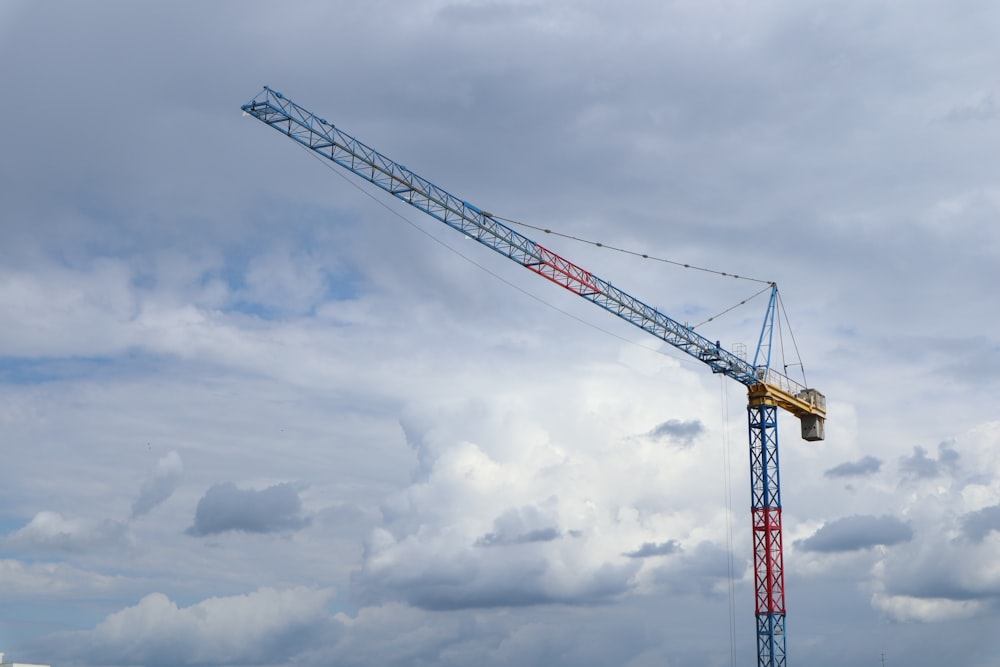 red and yellow crane under cloudy sky during daytime