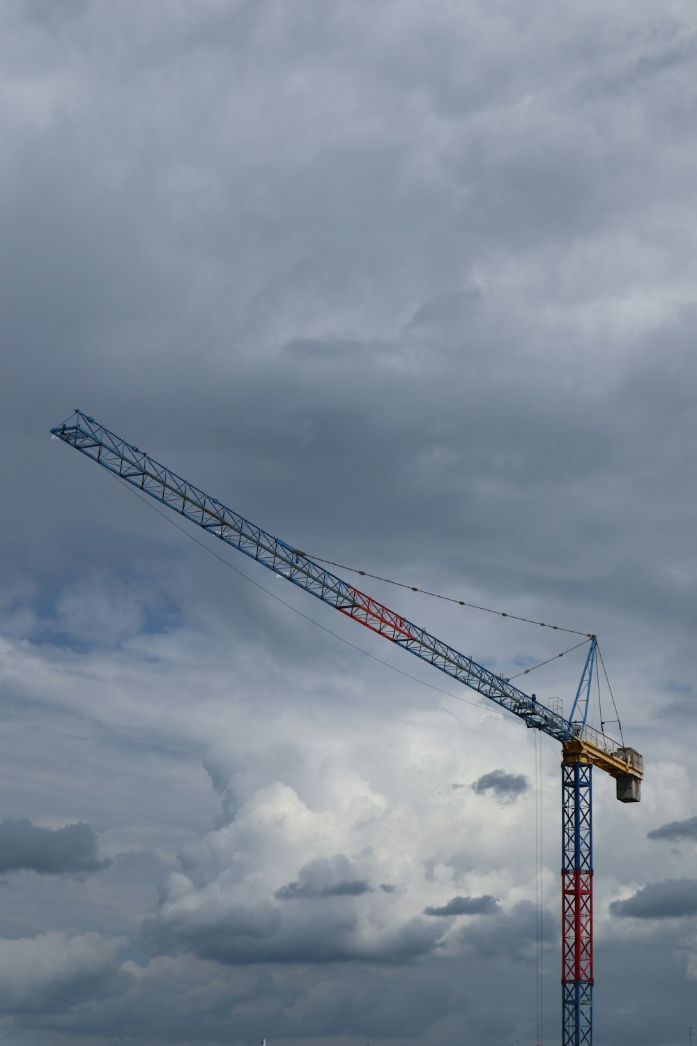 yellow crane under cloudy sky during daytime