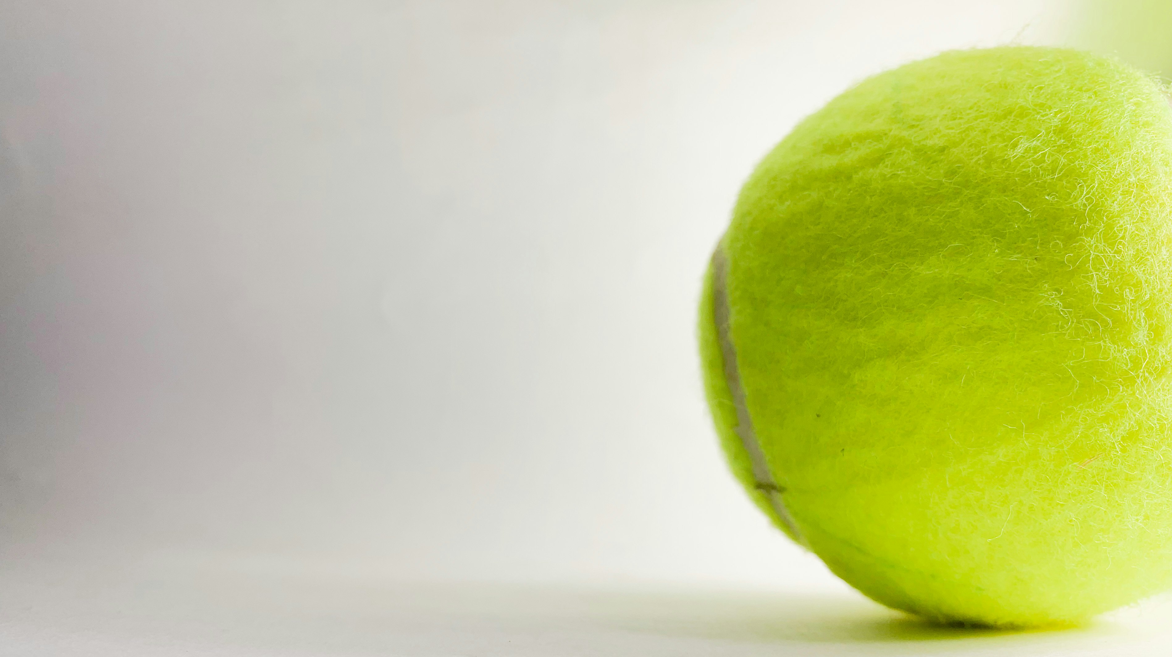 green tennis ball on white surface