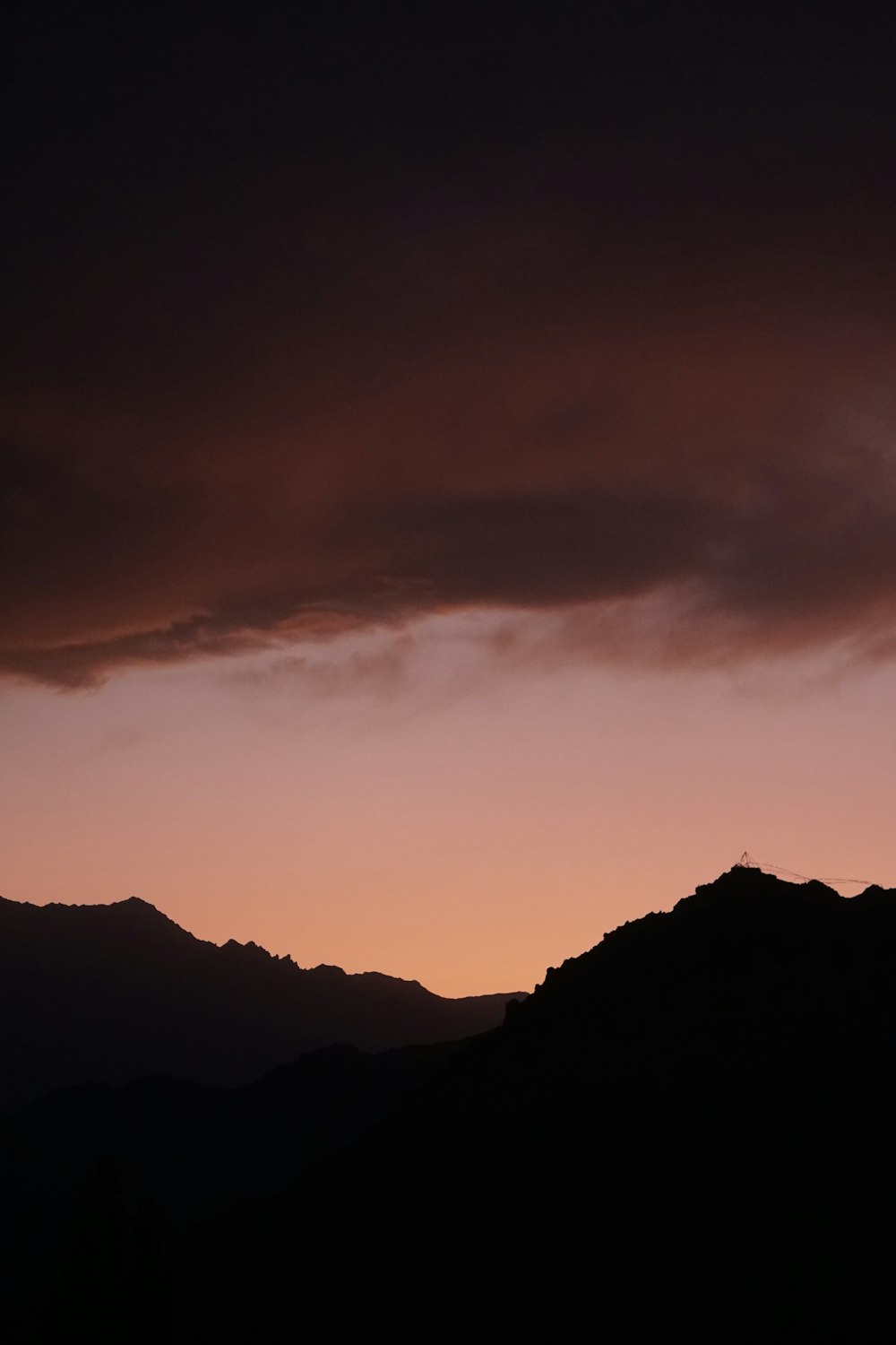 silhouette of mountains under cloudy sky during daytime