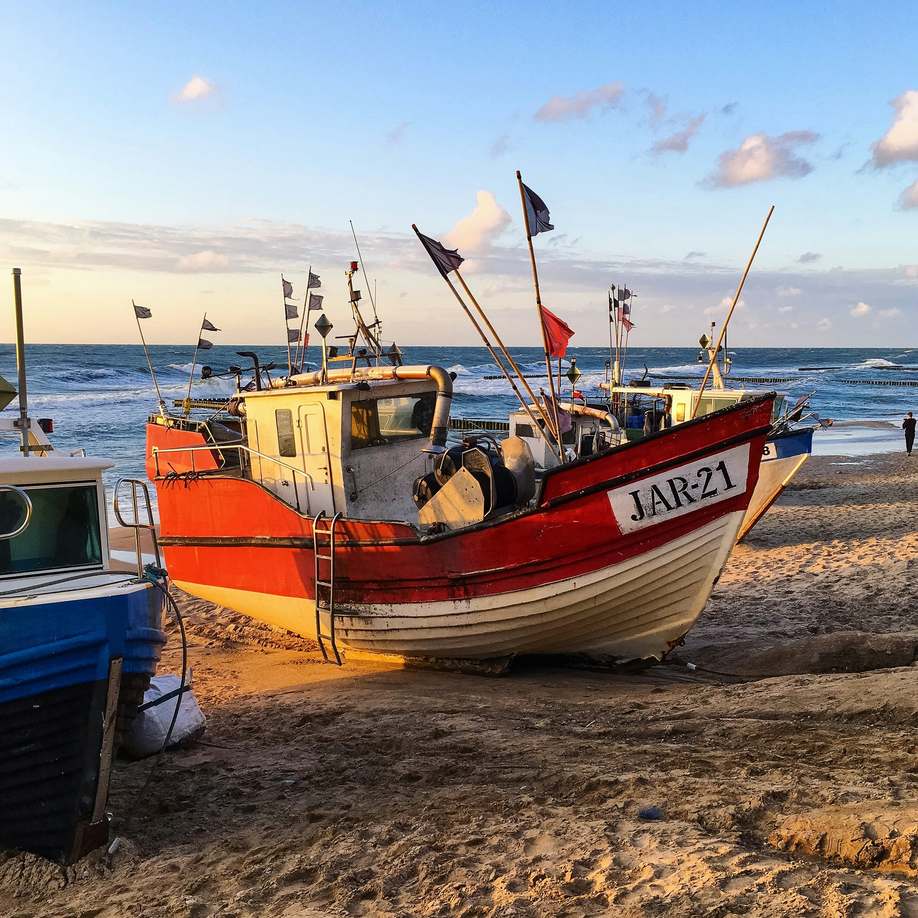 blue and brown boat on brown sand during daytime