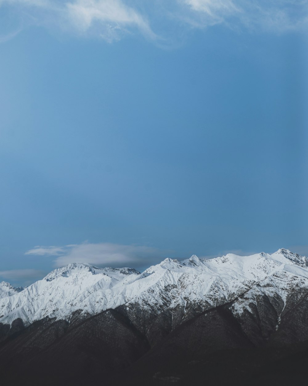 montanha coberta de neve sob o céu azul durante o dia