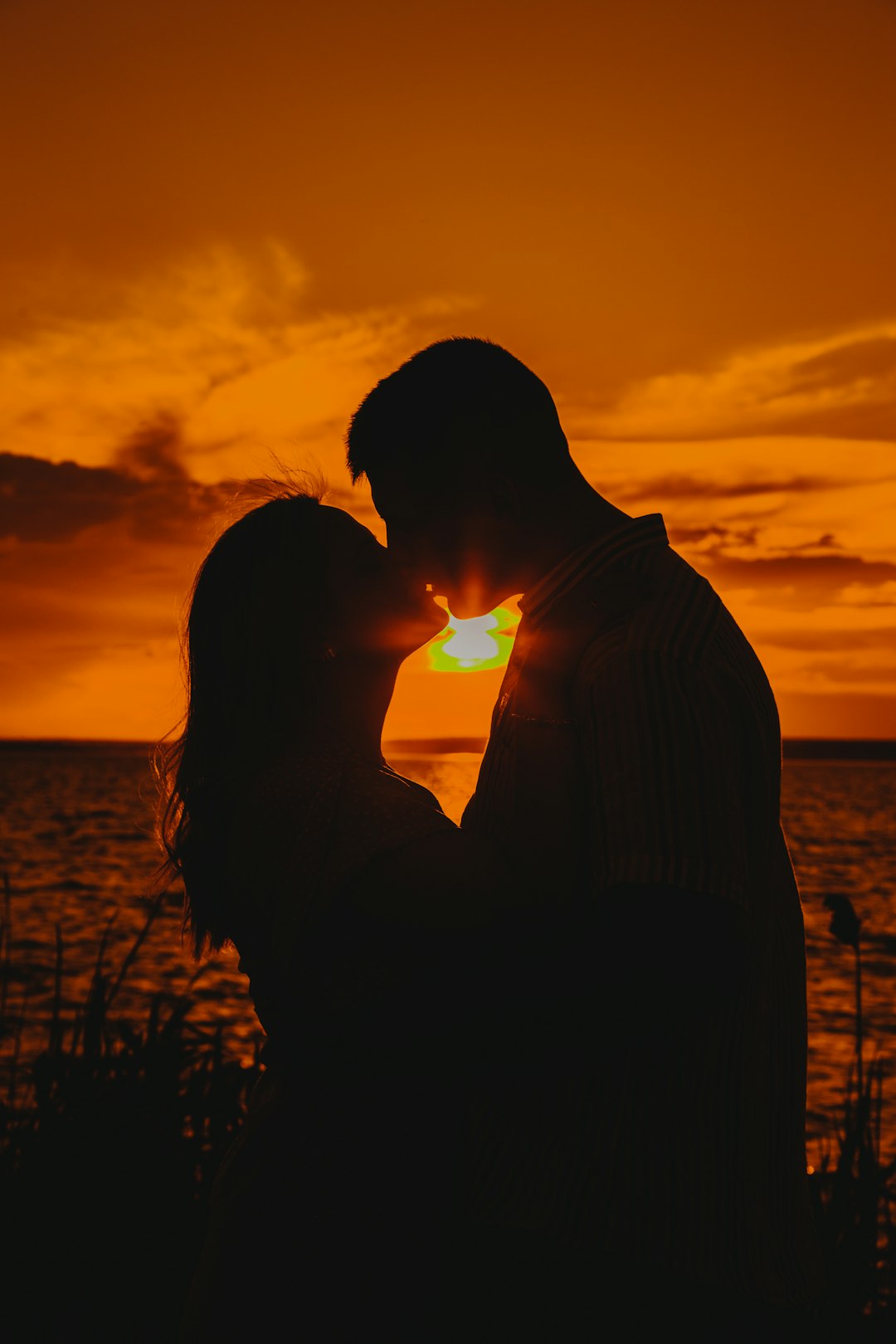 silhouette of man and woman kissing during sunset