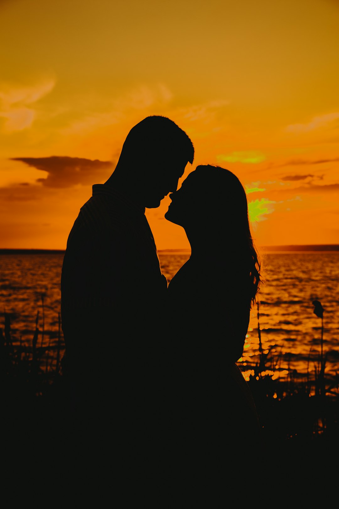 silhouette of couple kissing during sunset