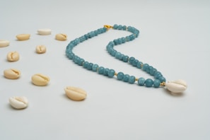 Close-up of a delicate ocean-inspired necklace with blue and white beads reflecting Okinawa's sea.