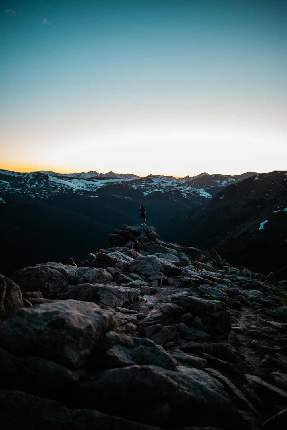 person standing on rocky mountain during daytime